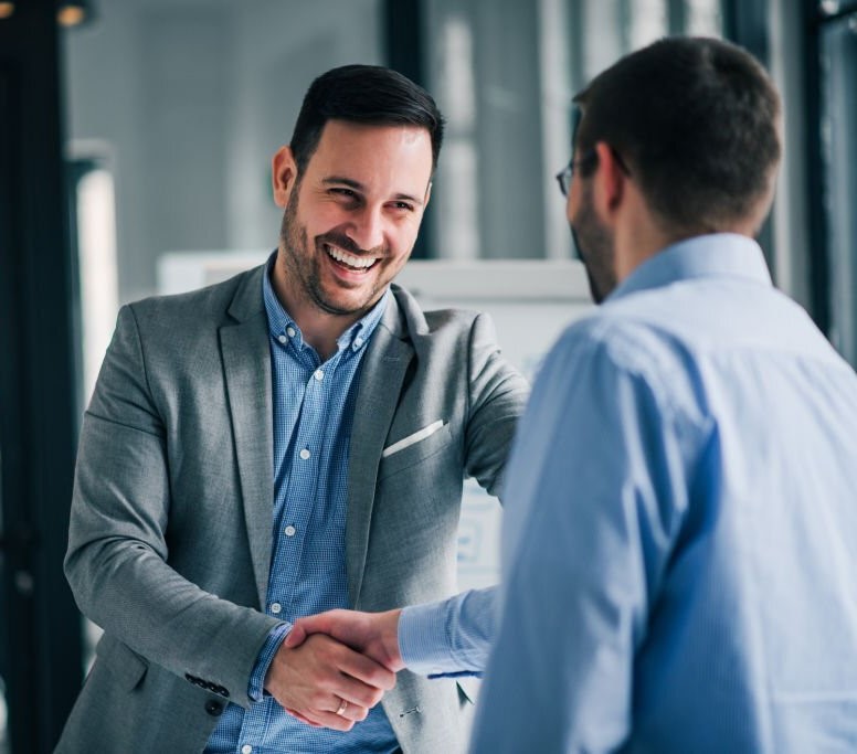 Portrait of cheerful young manager handshake with new employee.